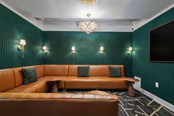 Media lounge with tan leather seating and wall sconces